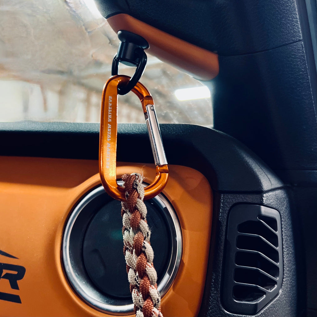 CMM Offroad quick-disconnect attachment holding keys beside Jeep dashboard — available from Offroad Trading Company