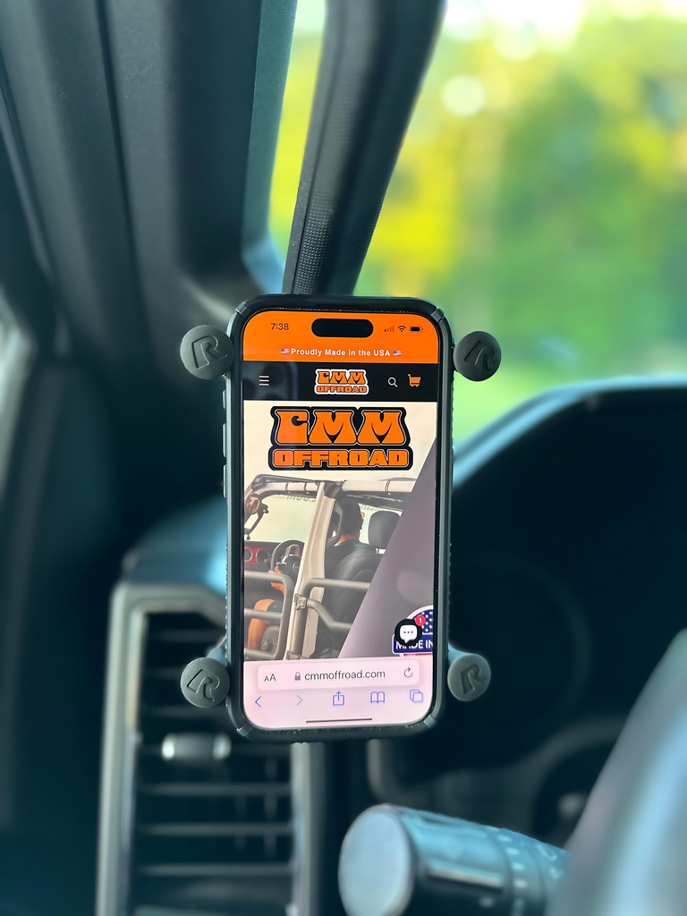 CMM Offroad phone displayed beside A-Pillar grab handle — available from Offroad Trading Company
